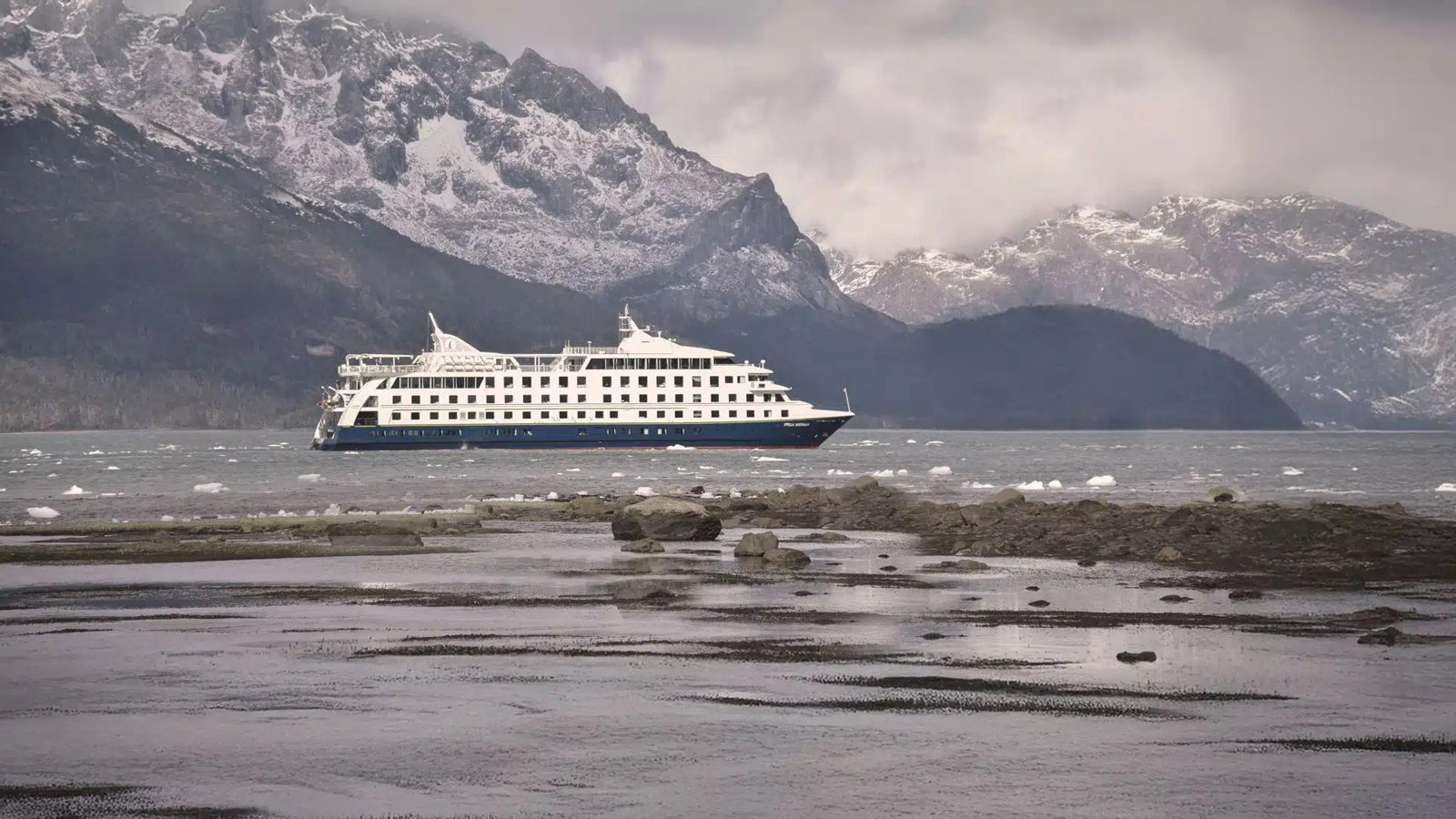 Barco de Australis entre montañas nevadas de la Patagonia