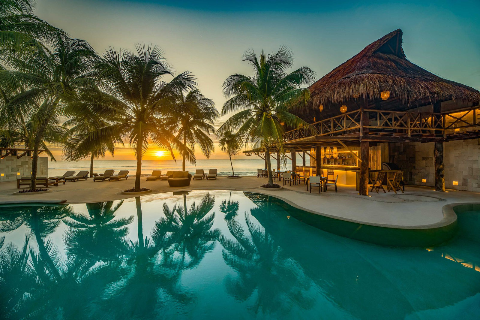 Pool and palapa at sunset at Viceroy Riviera Maya